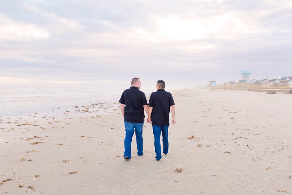 same sex couple walking along Sea Isle Beach in Galveston