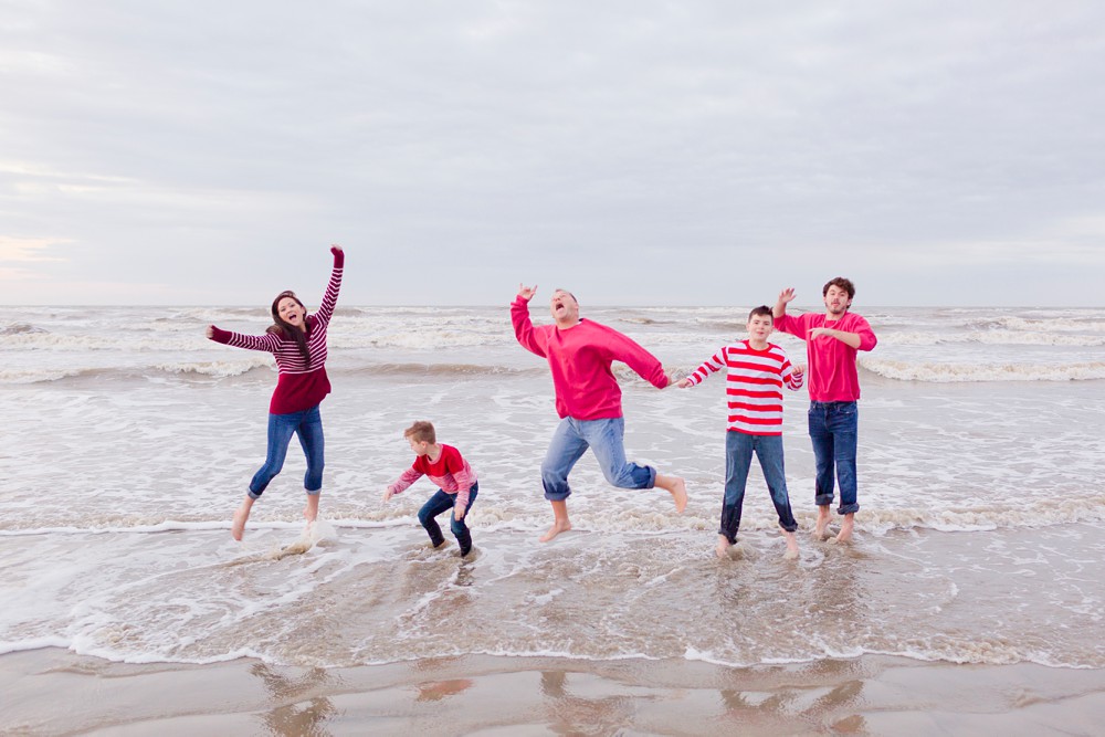 Family splashing in the water at Galveston beach session