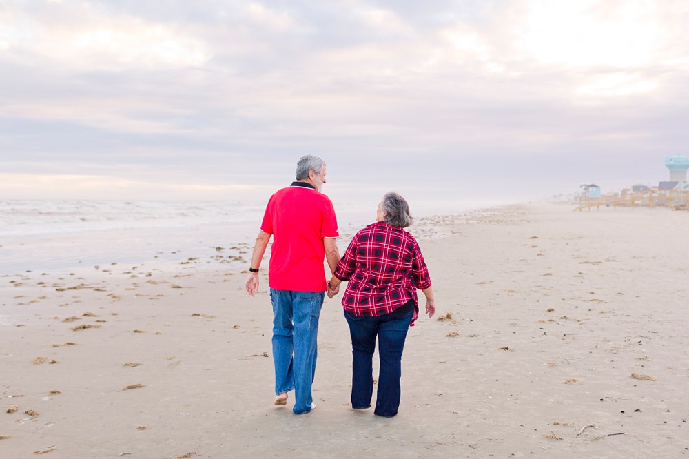 Grandparents walking along the beach at extended family beach session in Galveston