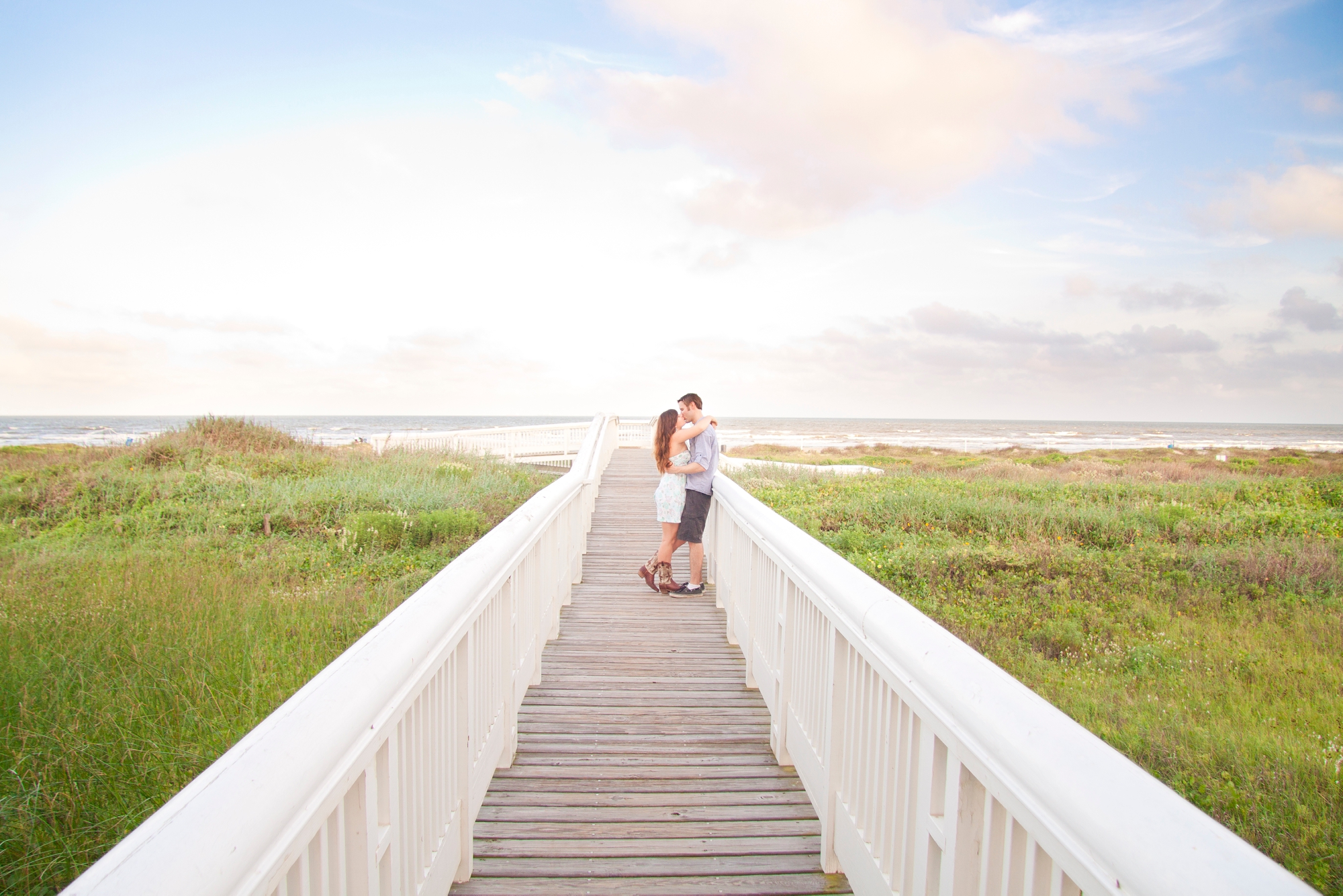 Couple embracing on a dune walkover in Beachtown, Galveston
