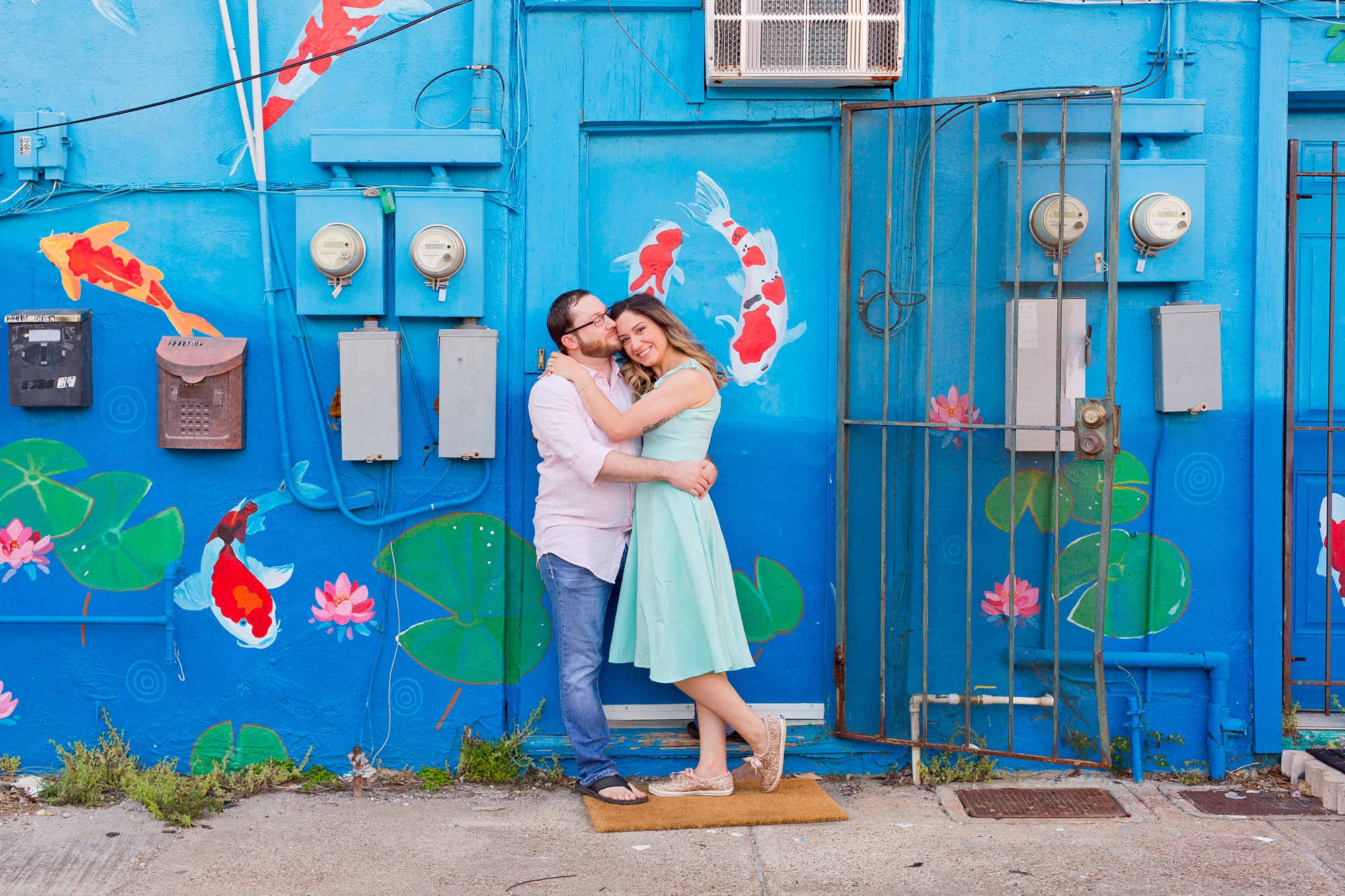 Couple in front of koi pond mural Galveston engagement session photo location