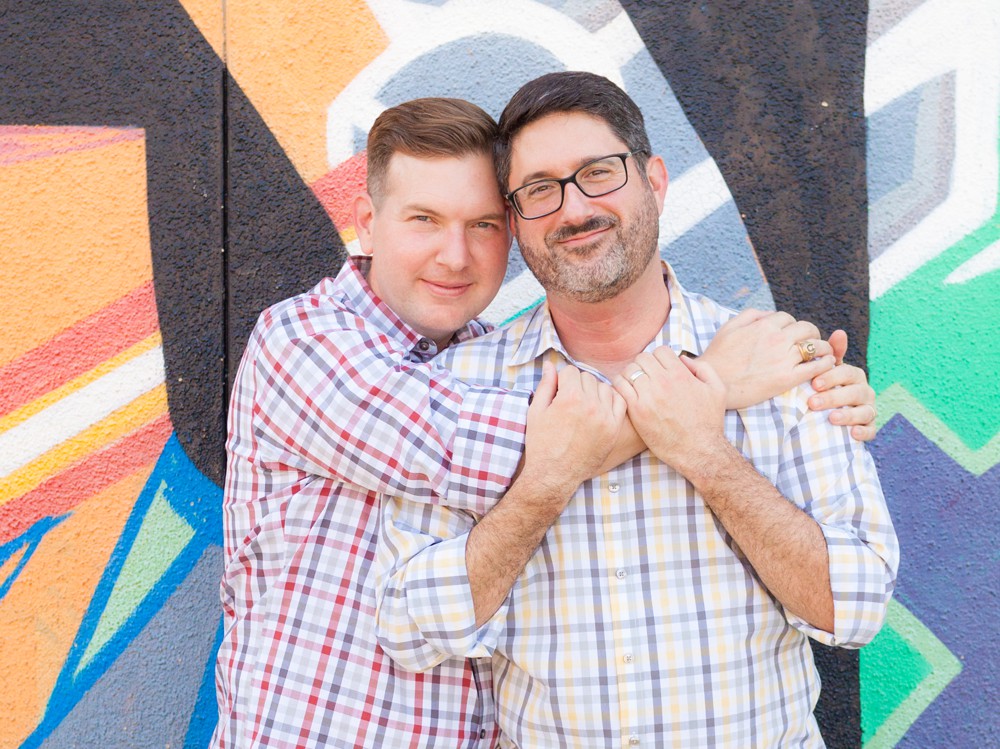 Gay couple in front of Houston mural; tips for newly engaged couples
