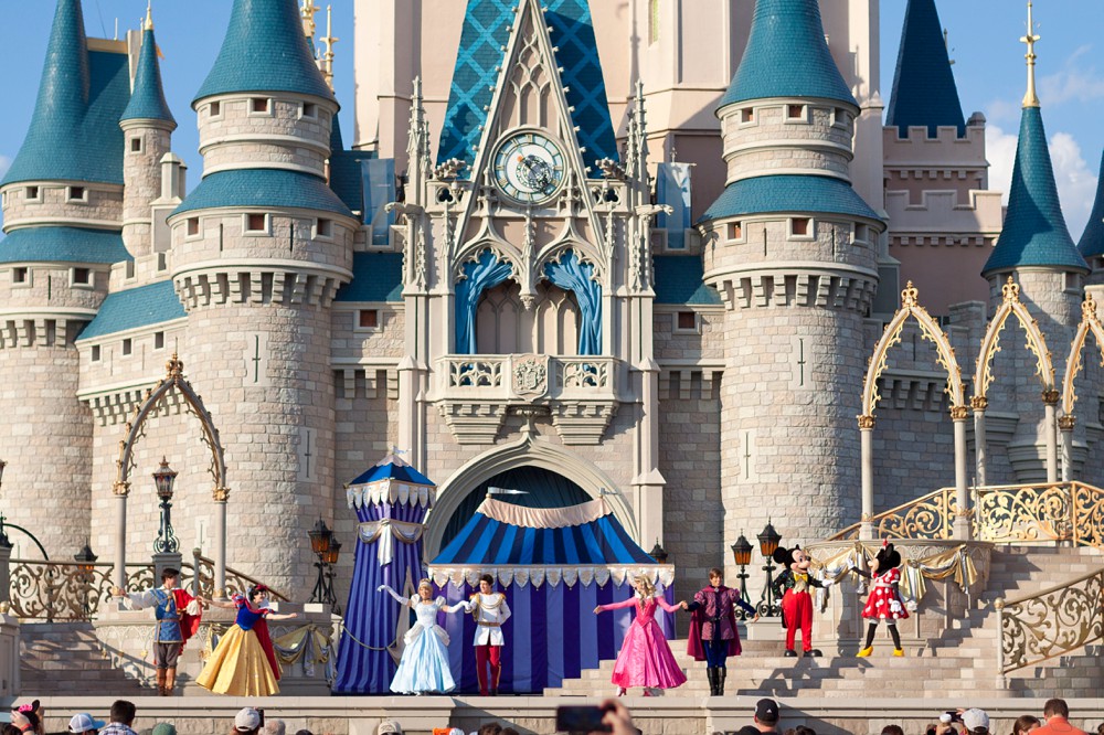 Disney princesses dancing in front of Cinderella's Castle