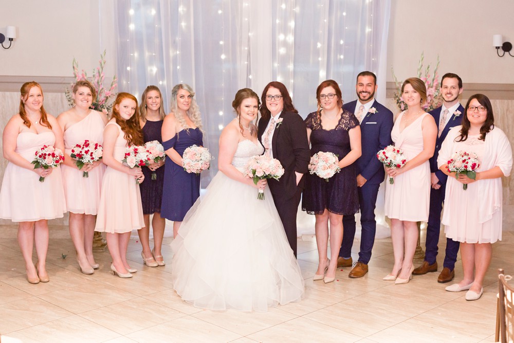 Bride and bride with wedding party in the ceremony room at Noah's Event Venue