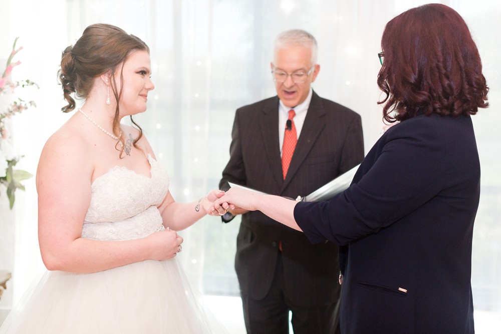 Brides exchanging rings during wedding ceremony