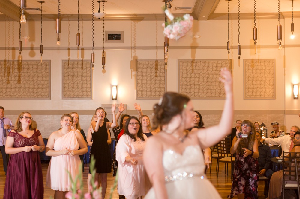 Bride tossing bouquet at wedding reception at Noah's Event Venue in Sugar Land Texas