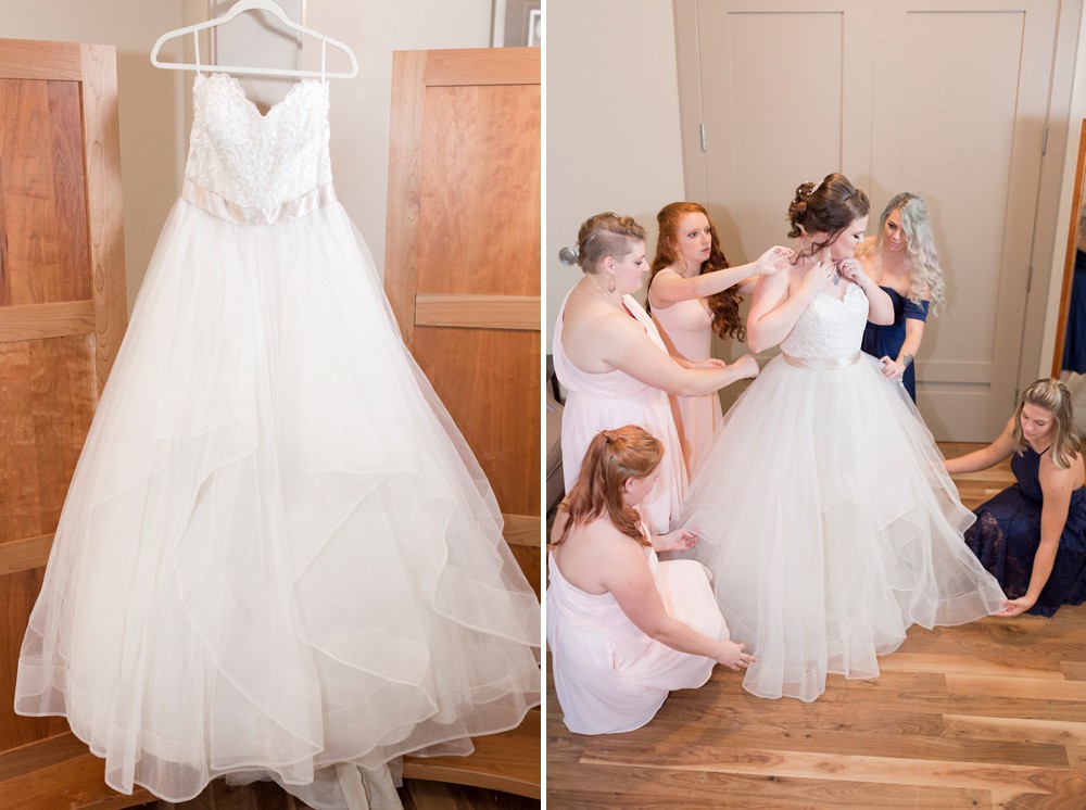 BHLDN wedding dress hanging in bridal suite and bridesmaids helping bride get dressed