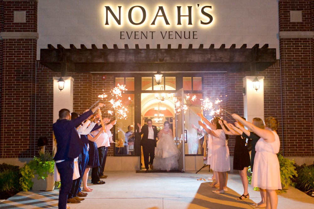 Wedding party and guests lined up for sparkler exit outside Noah's Event Venue in Sugar Land Texas