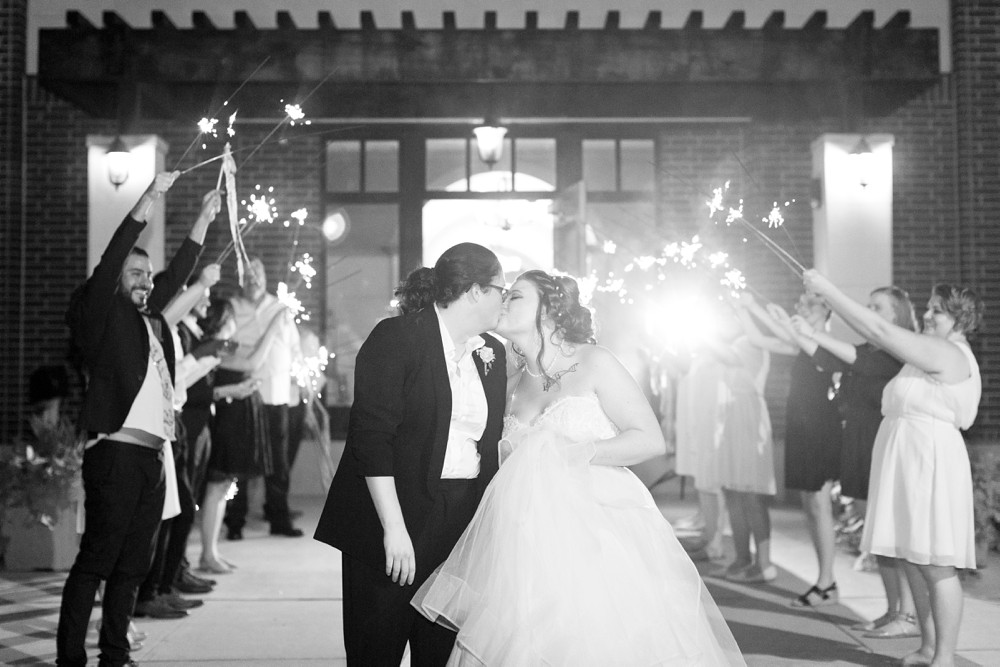Brides kissing after their sparkler exit at Noah's Event Venue in Sugar Land Texas