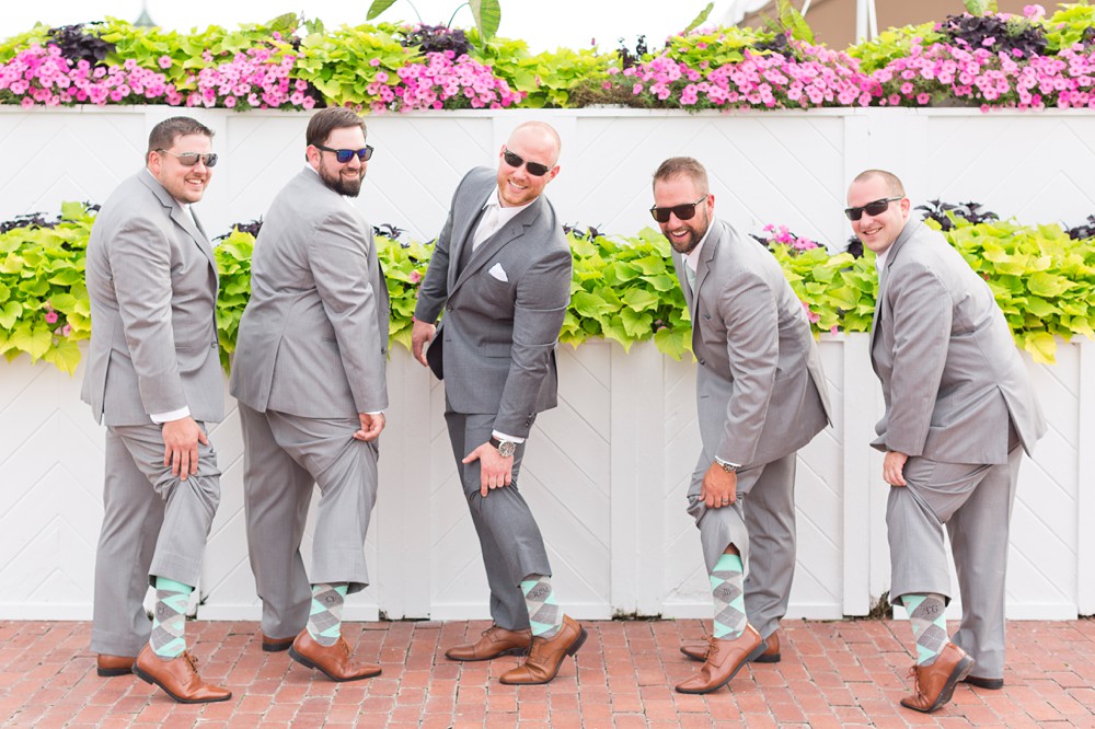 Groom and groomsmen showing off socks near the Promenade Deck at Mission Point Resort