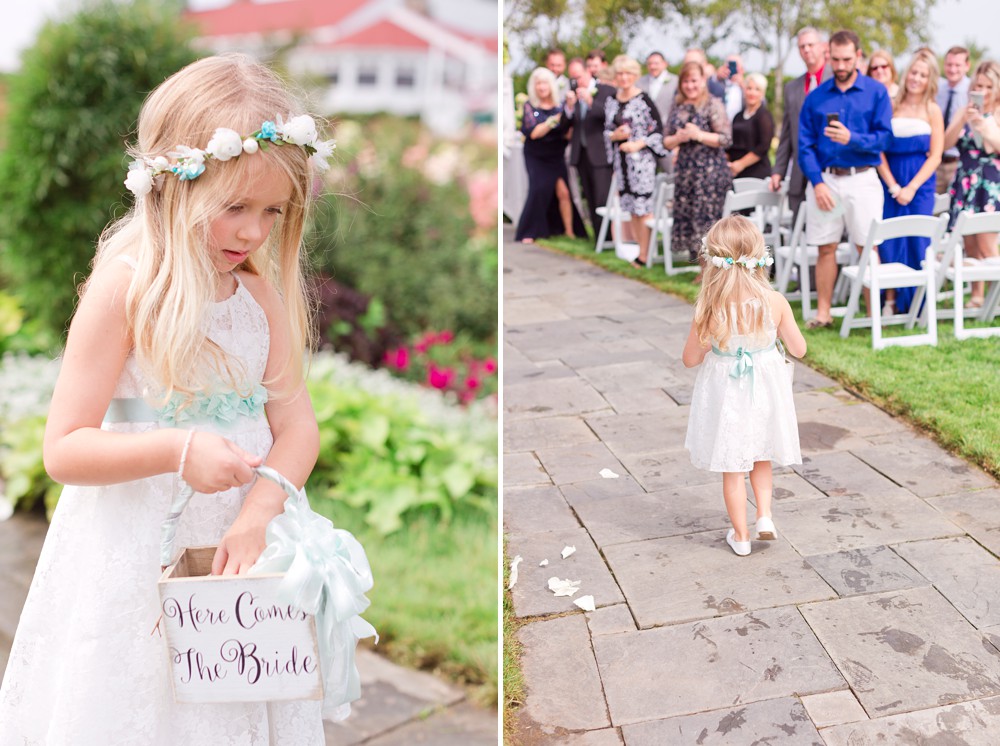 Flower girl walking down the aisle holding hear comes the bride basket