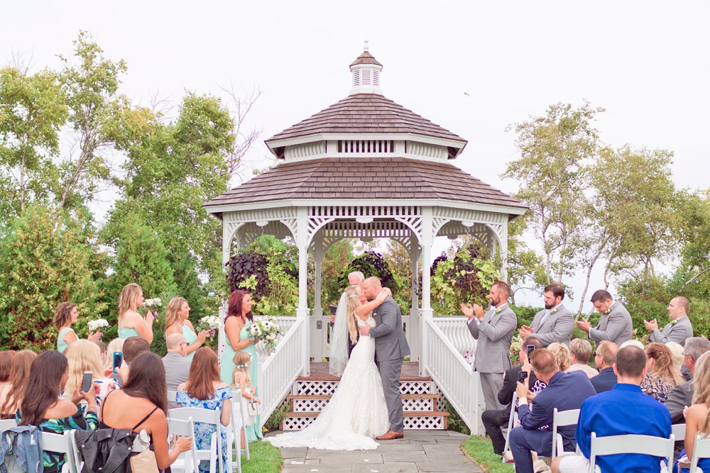 Bride and groom kissing in front of Mission Point wedding gazebo