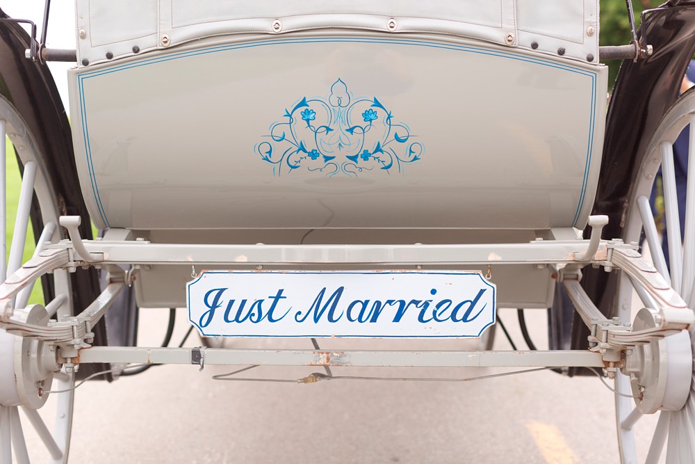 Just married sign on the back of a horse drawn carriage