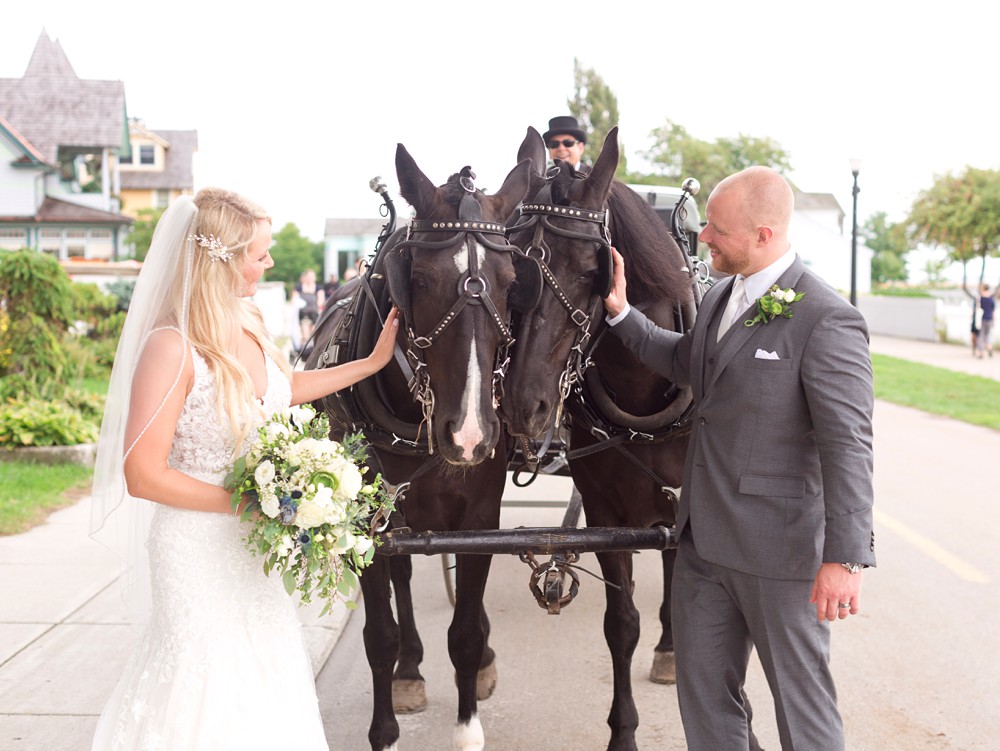 Bride and groom petting horses on Main Street
