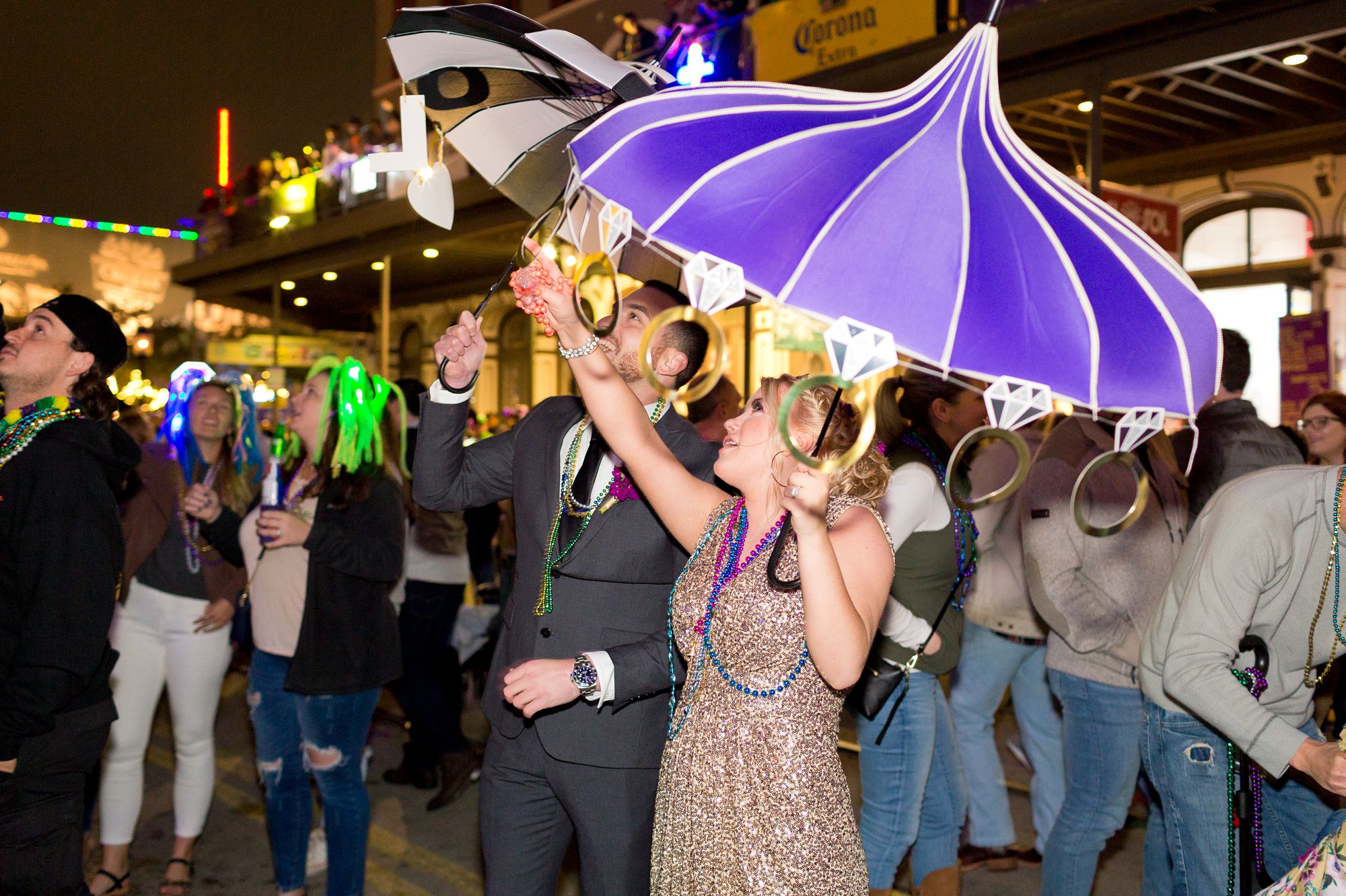 A bride and groom catching beads at their Mardi Gras elopement in Galveston, Texas.