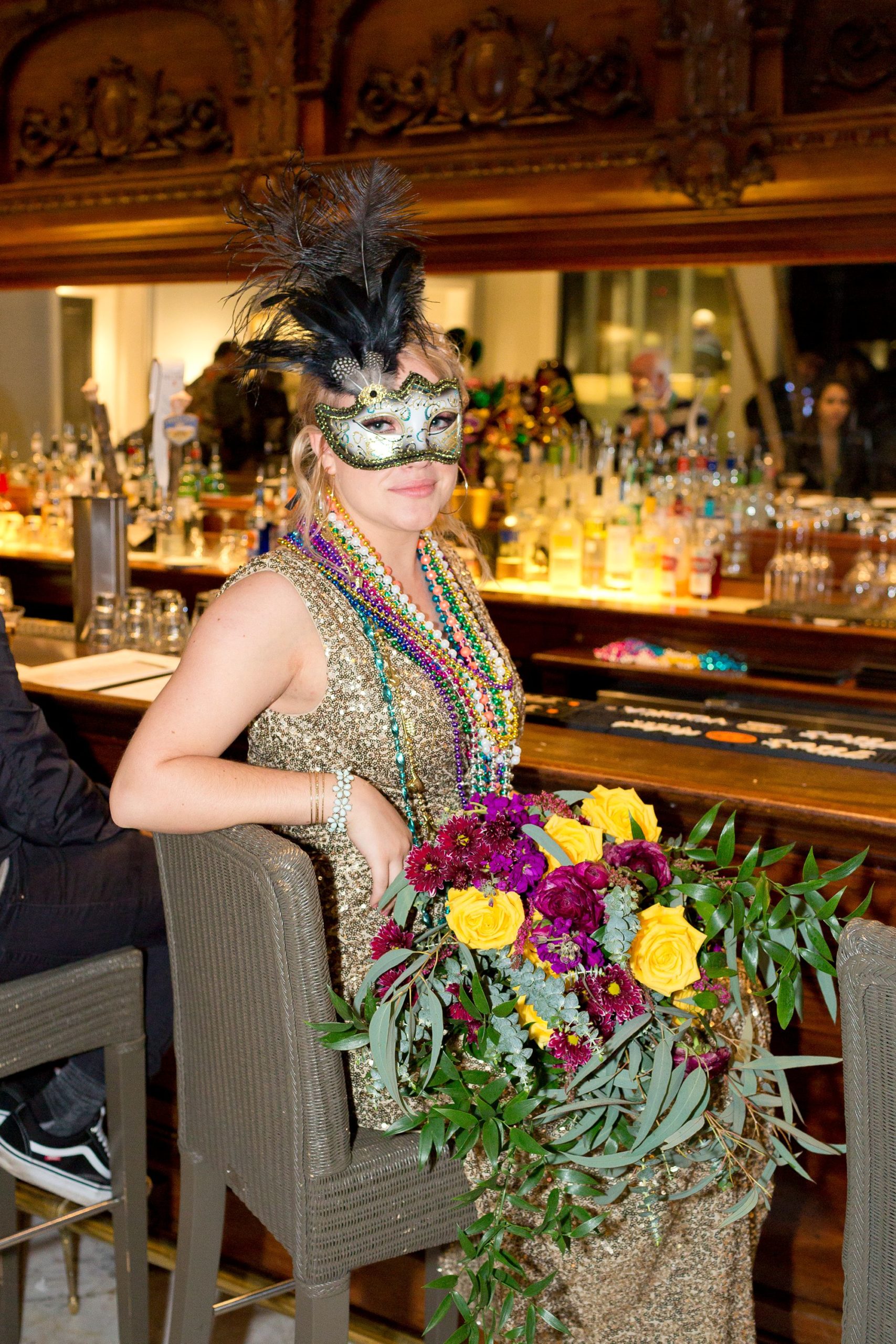 A bride in a gold sequin dress and masquerade mask at her Mardi Gras Galveston elopement.
