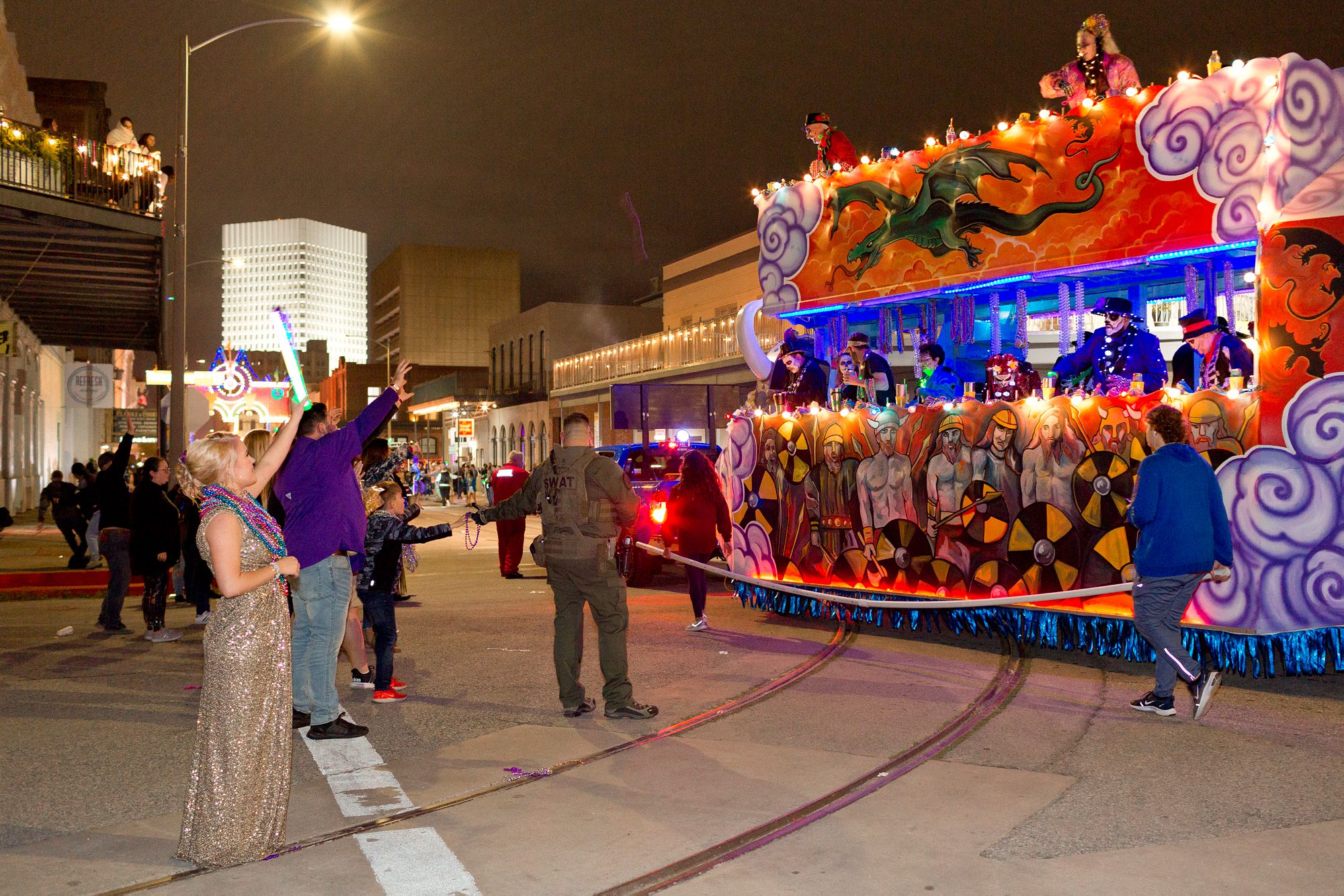 A bride and groom watch a Mardi Gras parade in Galveston, Texas.