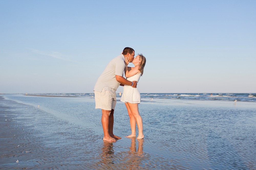 Couple taking engagement photos on Galveston Island beach