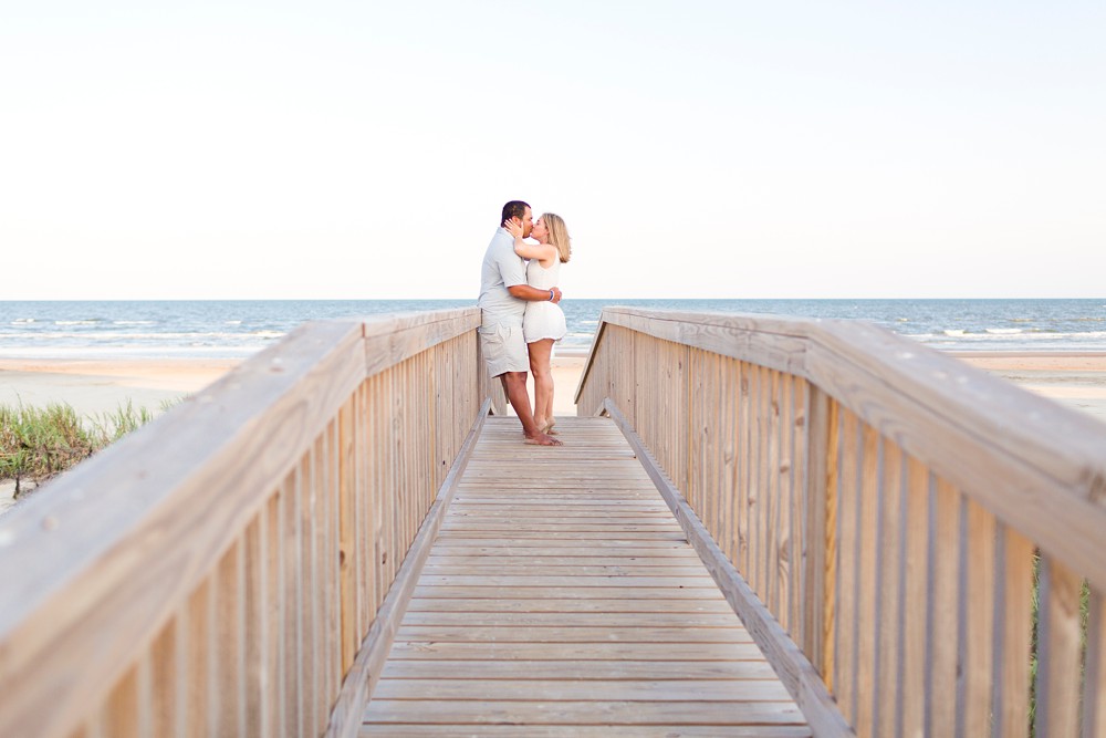 Couple on Galveston beach dune walkover during their engagement session