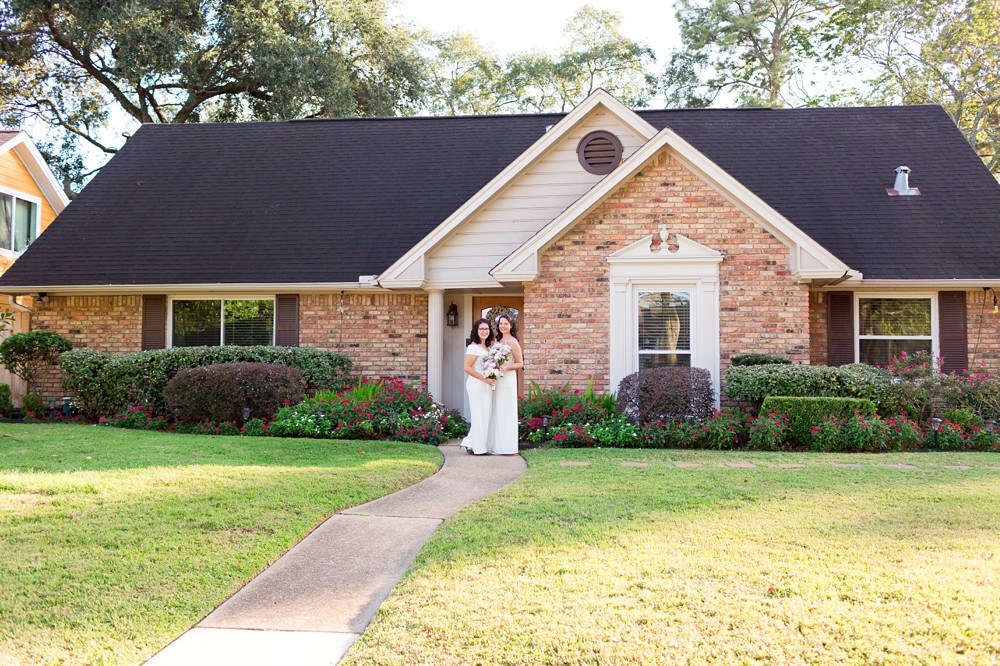 Brides in front of their home