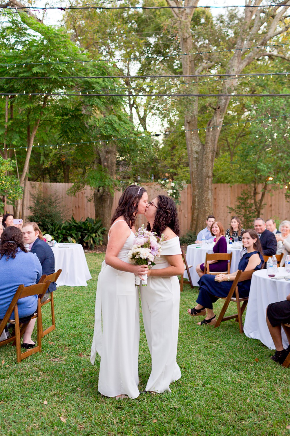 Brides kissing in the aisle during livestreamed wedding ceremony