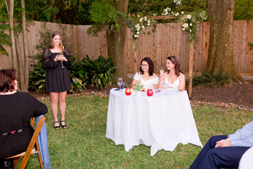 Bride's sister giving a wedding toast at backyard wedding