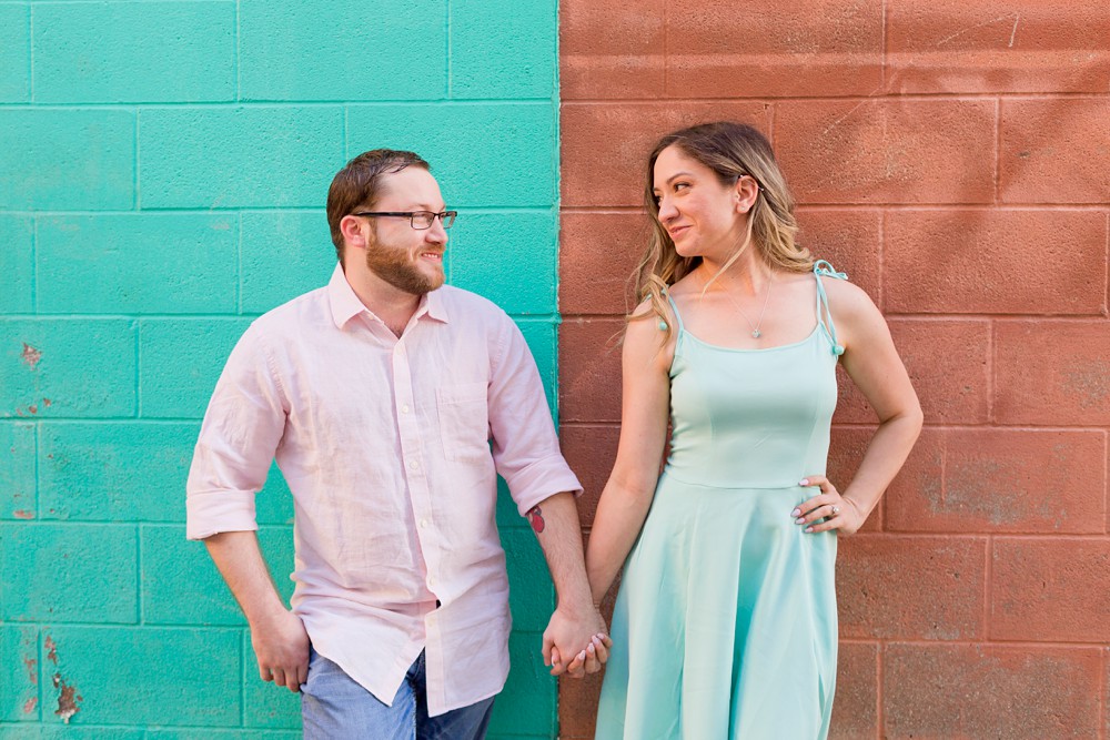 couple in front of painted brick wall