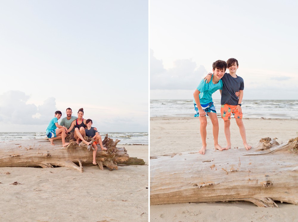 family sitting on a large piece of drift wood at their Galveston beach family session