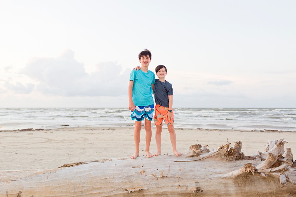 Two brothers on a large piece of driftwood at Sea Isle Beach