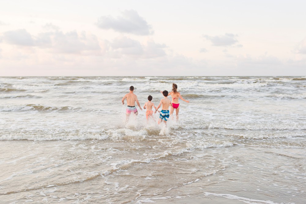 family running into the waves at Galveston beach
