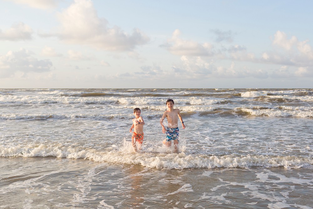 two brothers running out of the water at Galveston beach