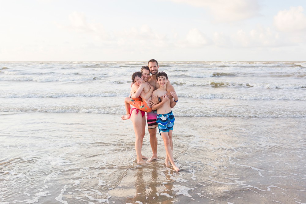 family hugging each other at their Galveston beach family session