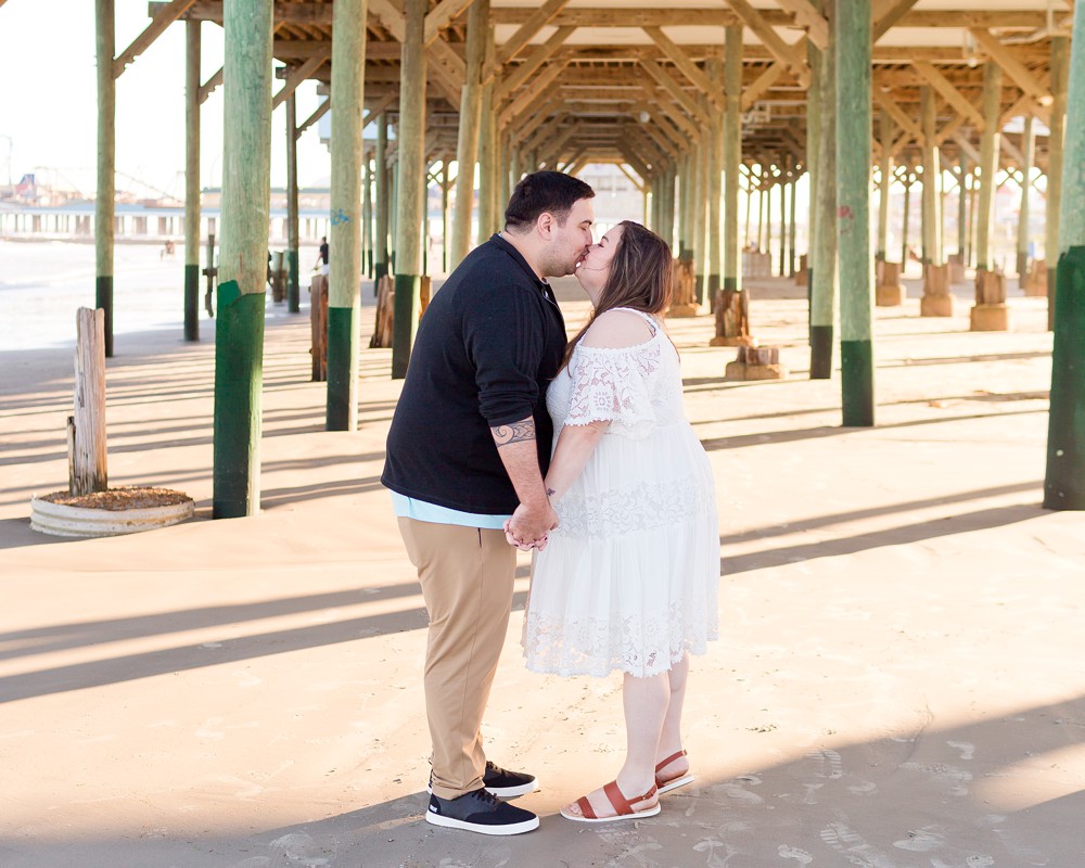 Couple kissing with Murdochs pier in the background