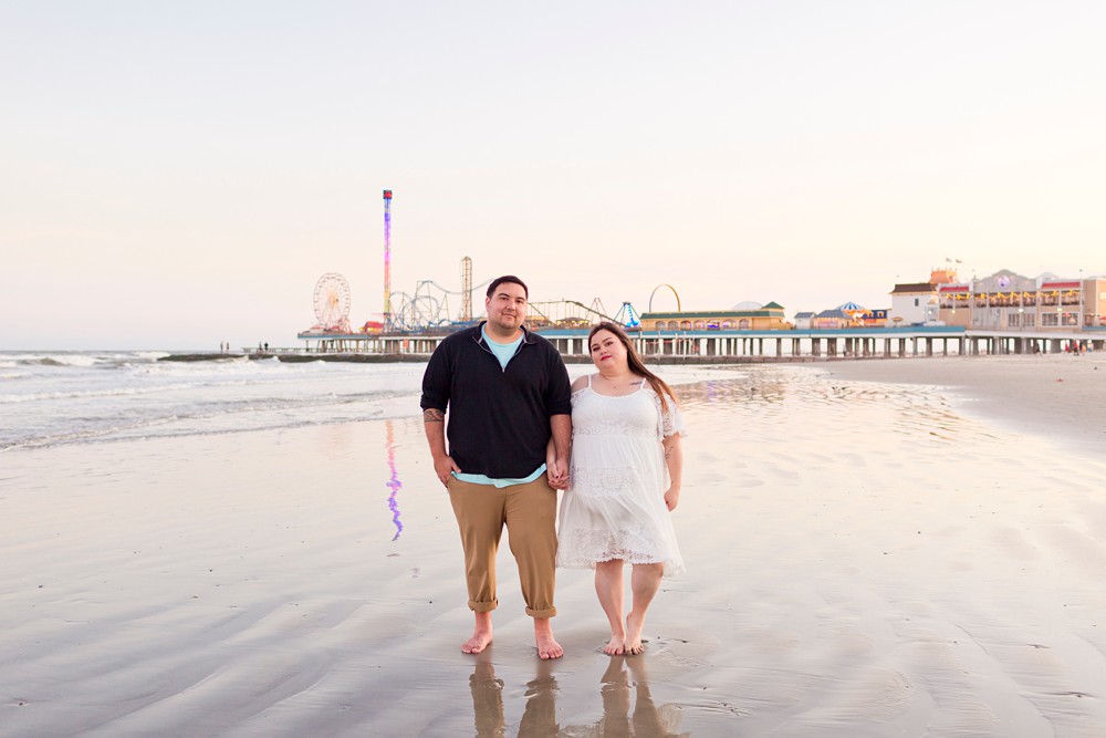 Couple on Galveston Beach with Pleasure Pier in the background