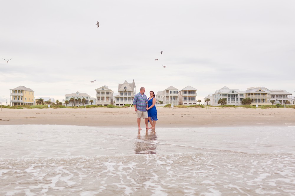 Couple watching seagulls on a Galveston beach near Beach Town