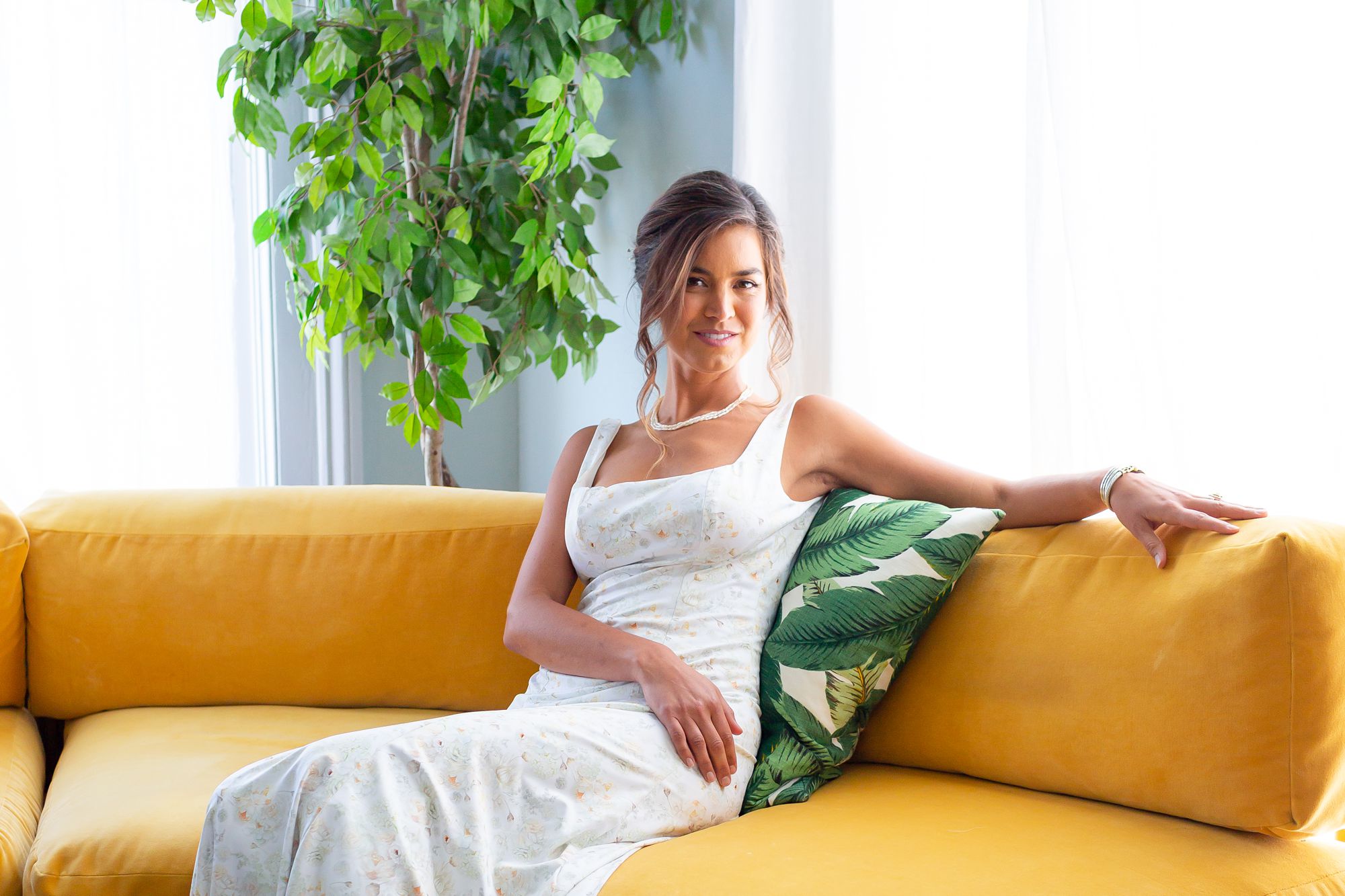 A bride sits on a yellow couch.