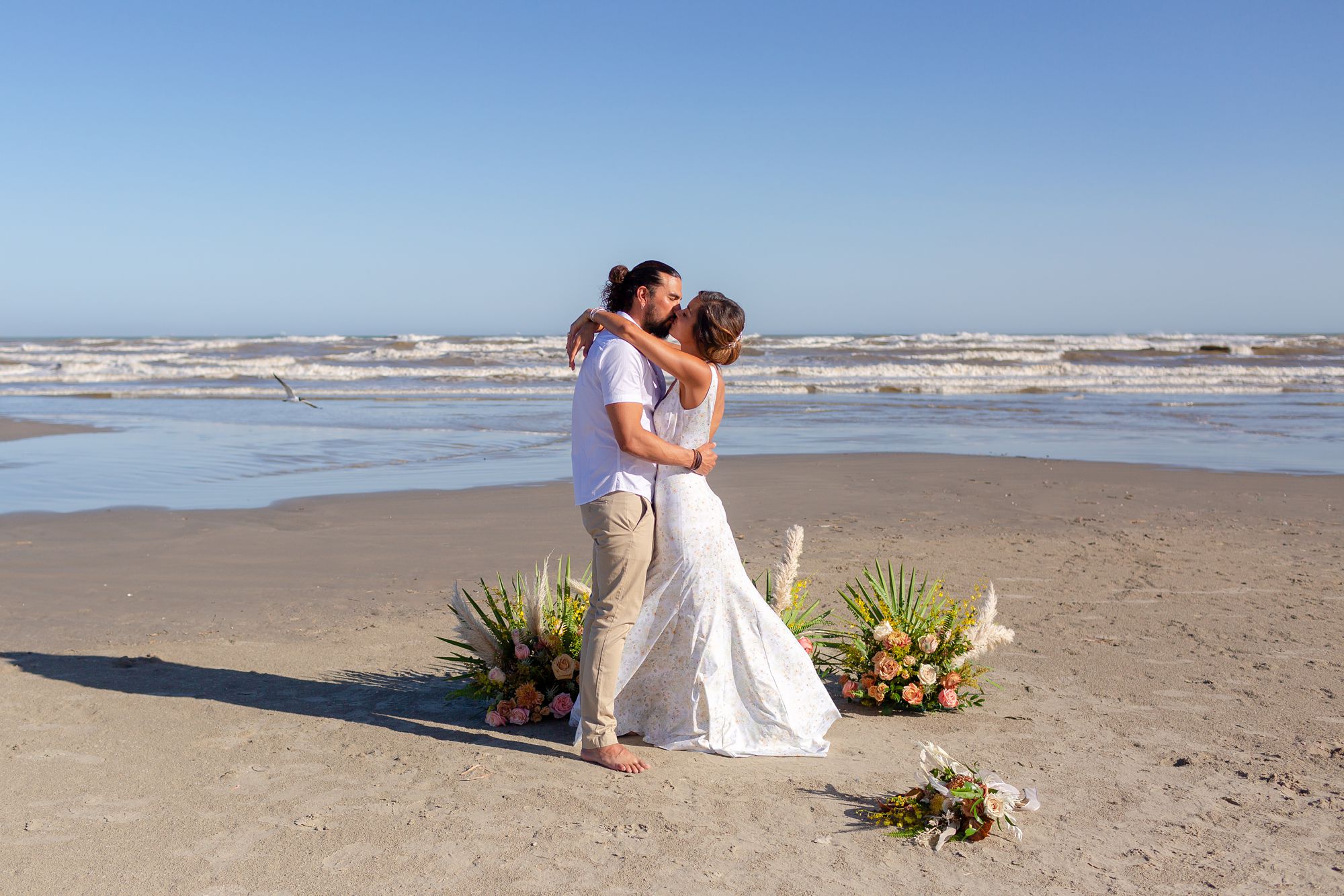 A bride and groom embrace in a kiss at their Preserve at Grand Beach elopement in Galveston.