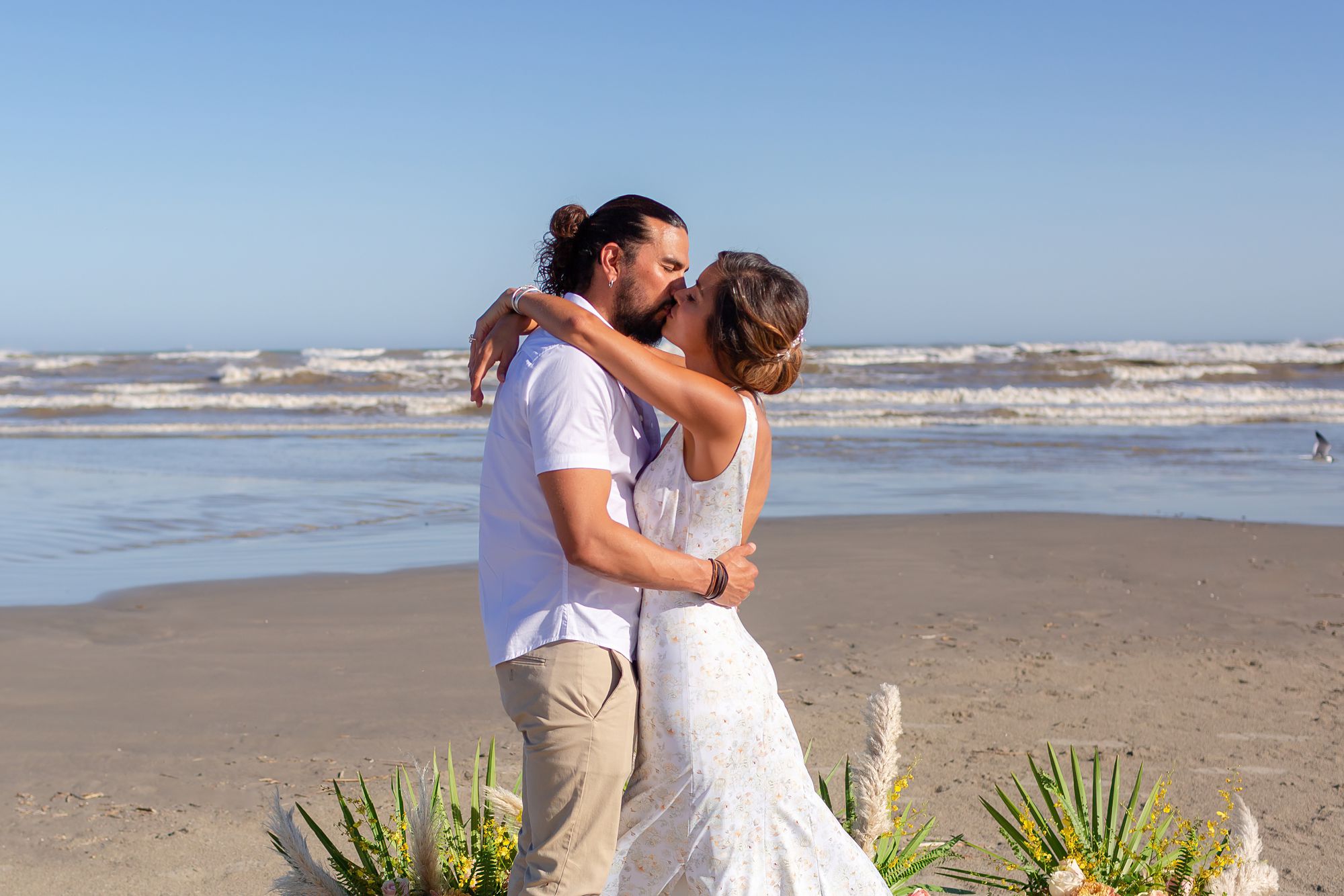 A bride and groom embrace in a kiss at their Preserve at Grand Beach elopement in Galveston.