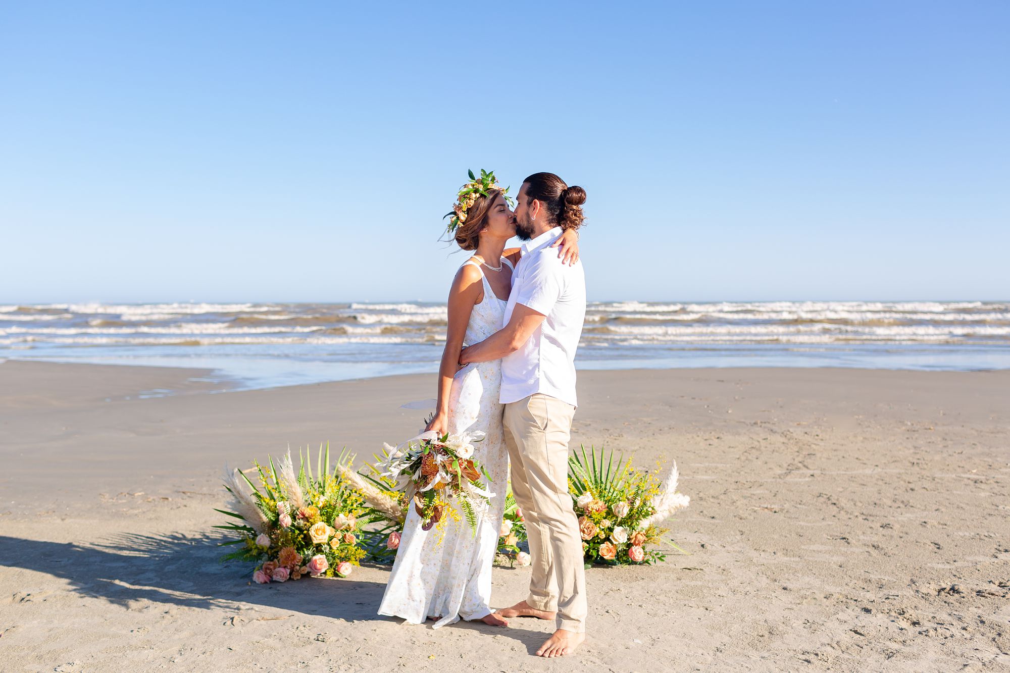 A couple embraces in a kiss at their Preserve at Grand Beach elopement with the ocean in the background.