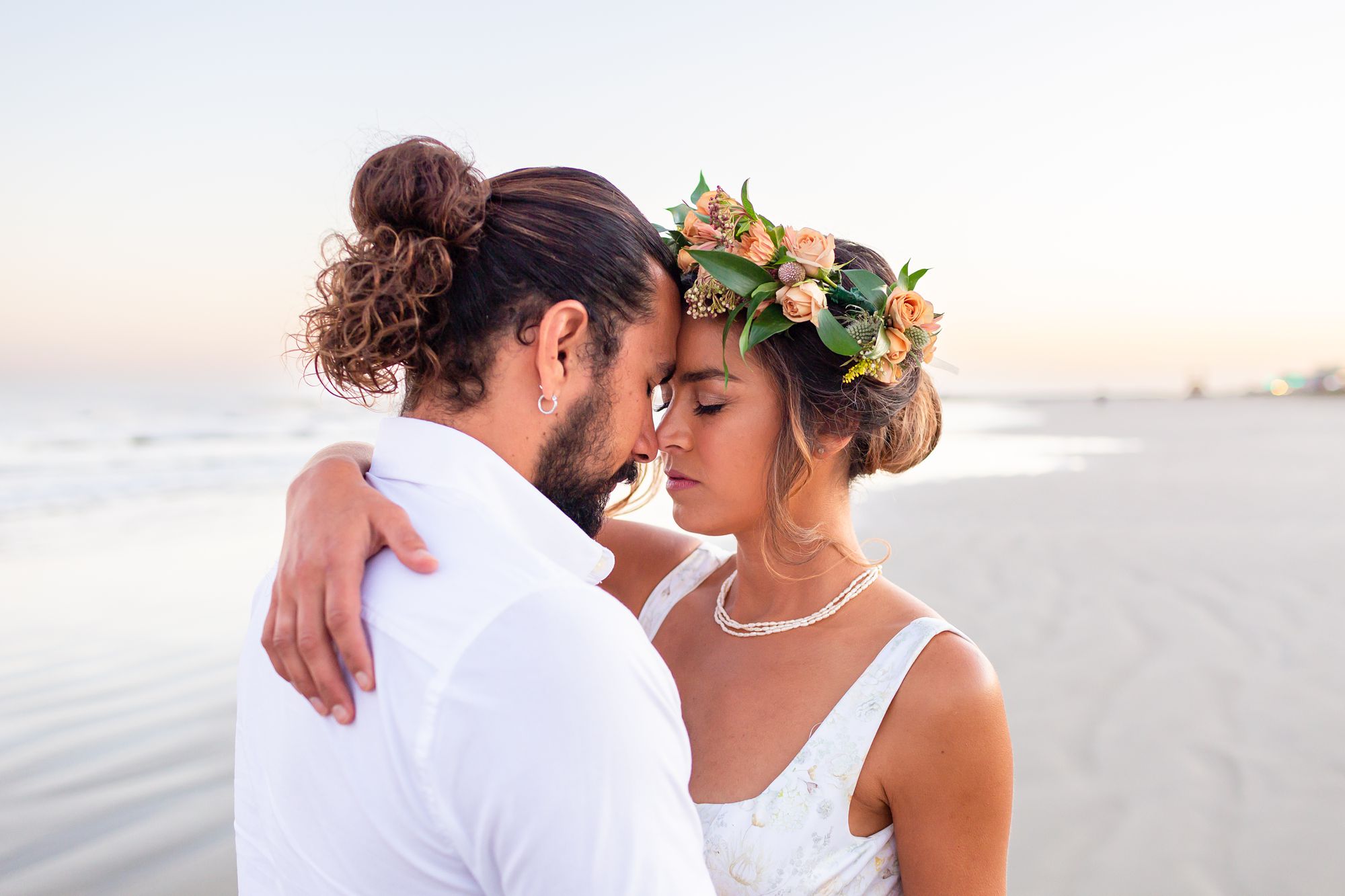 A bride and groom rest their foreheads together while embracing at their Preserve at Grand Beach elopement.