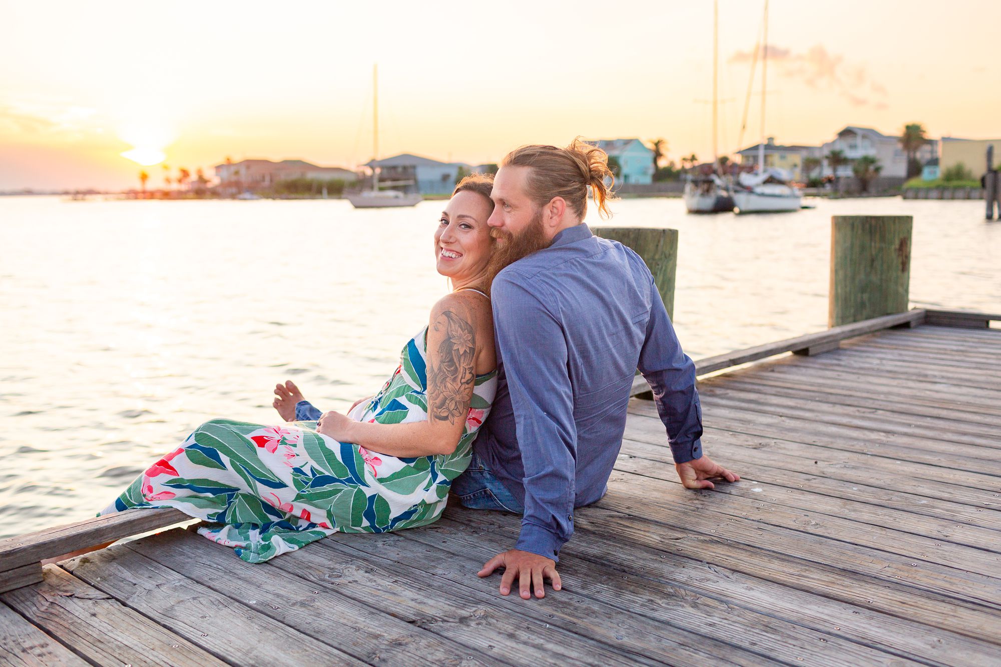 Couple sitting on a boat dock at Lee and Joe Jamail Bay Park couple session in Galveston.
