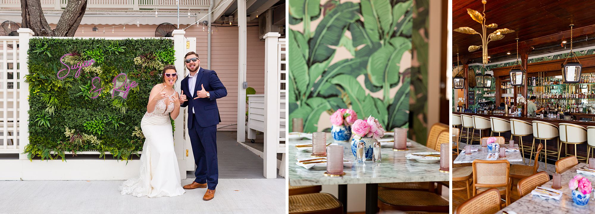 A bride and groom are standing next to the Sugar and Rye entrance sign, wearing sunglasses, and playfully sticking their tongues out at the camera. The image shows the interior of Sugar and Rye, with a white table set with flowers in front of pink wallpaper with frond leaves on it, and the wood and glass bar.