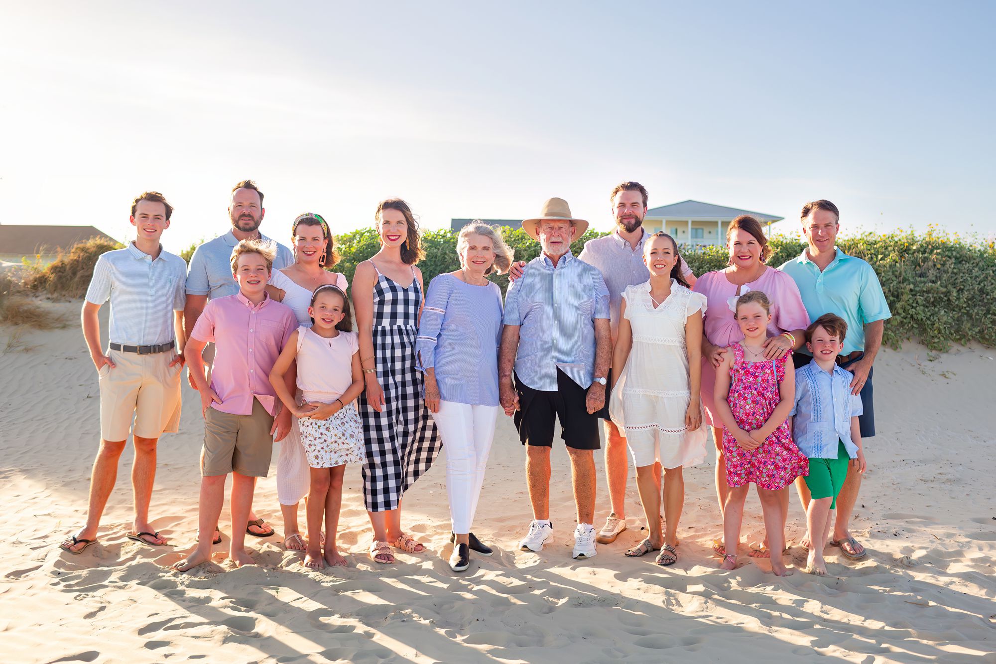 A couple stands on the beach with their children and grandchildren at a Crystal Beach Extended Family session in Texas.