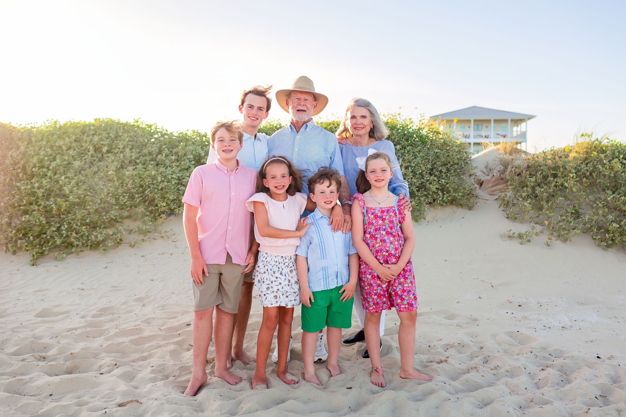 Grandparents stand with their grandchildren near a dune at a Crystal Beach Extended Family session.