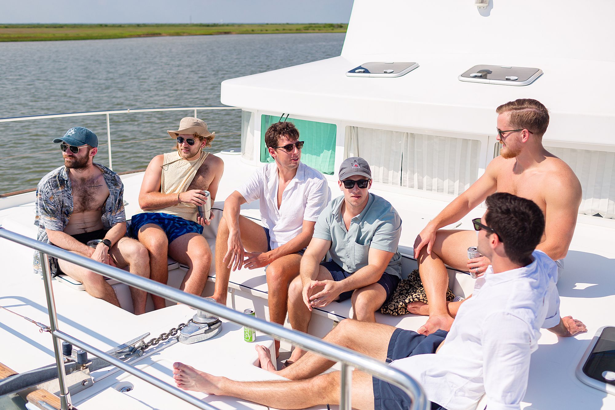 A group of men have drinks on a catamaran in Galveston.