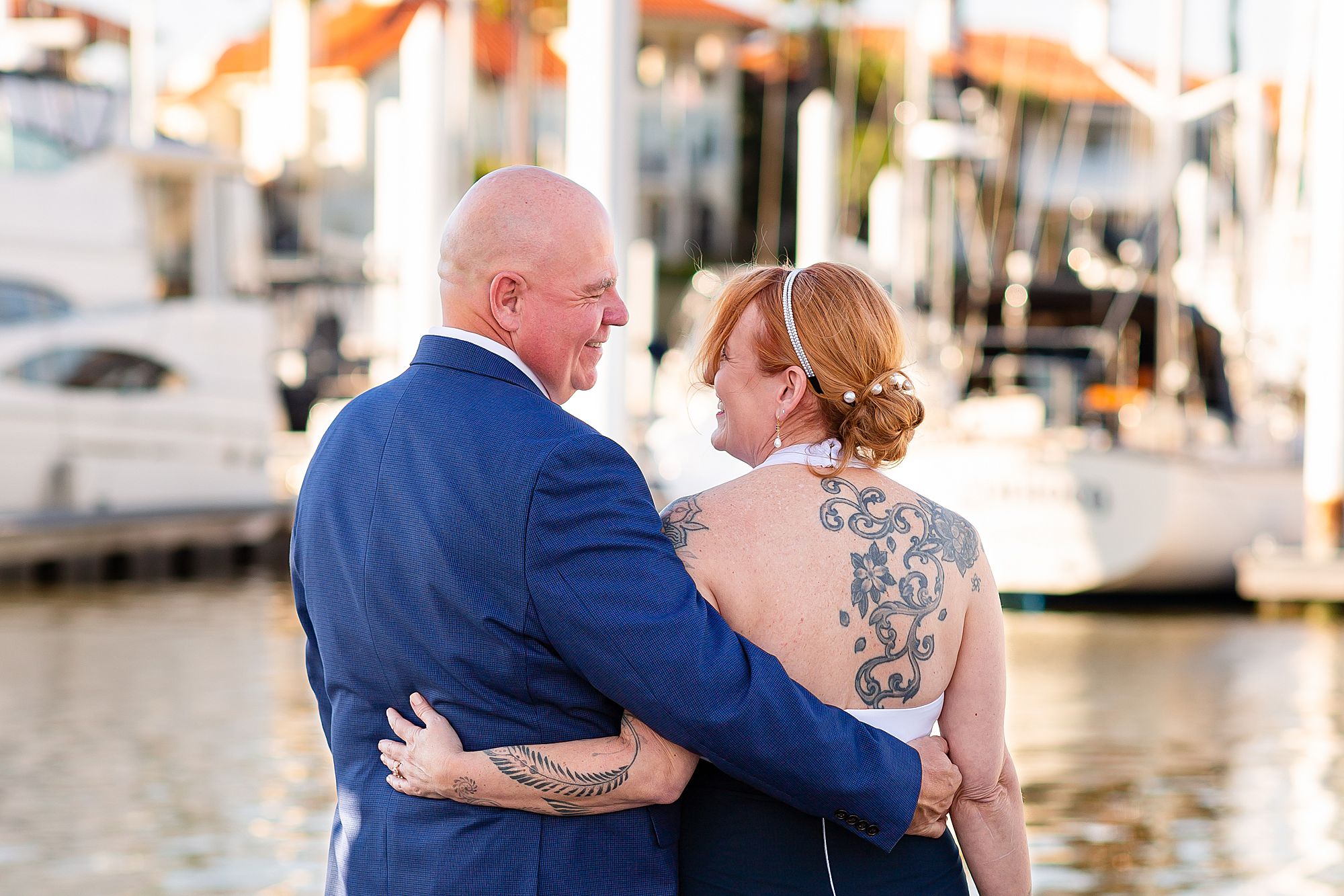 A bride and groom look into each other's eyes on a dock in Kemah, Texas.