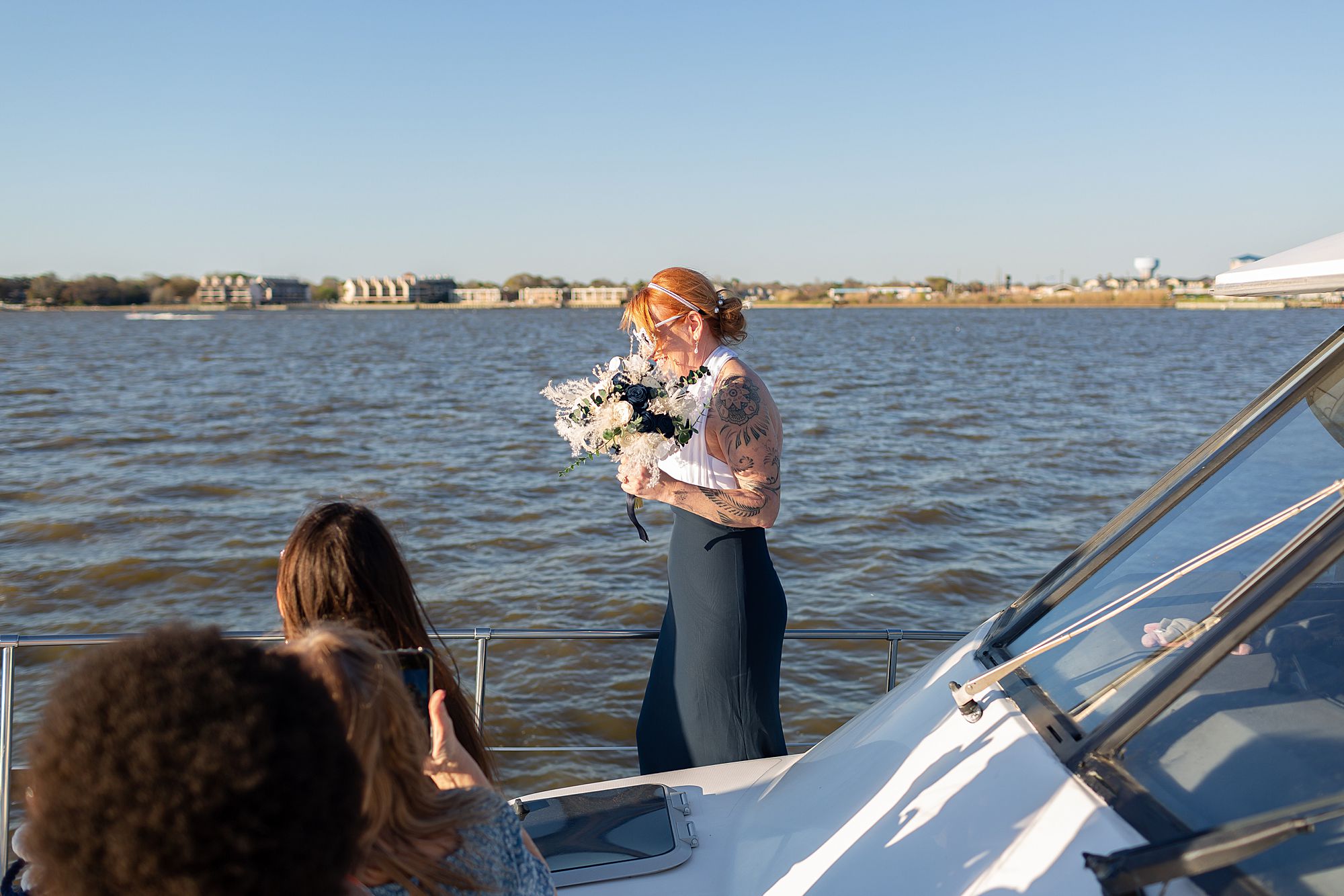 A bride walking to the bow of a yacht for her elopement ceremony on Clear Lake in Kemah, Texas.