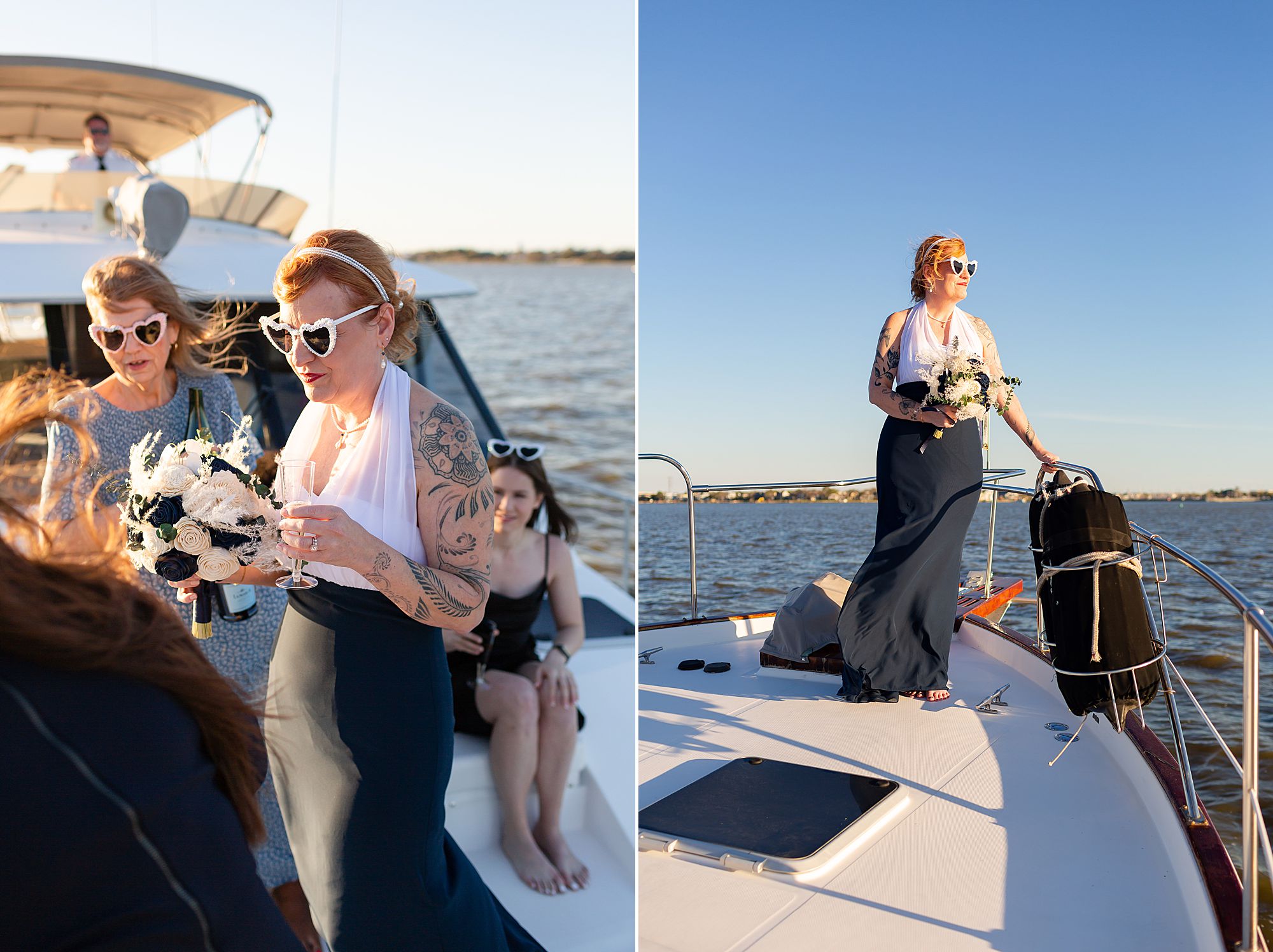 A bride wearing heart shaped sunglasses stands on the bow of a yacht looking out at the water as her dress blows in the wind.