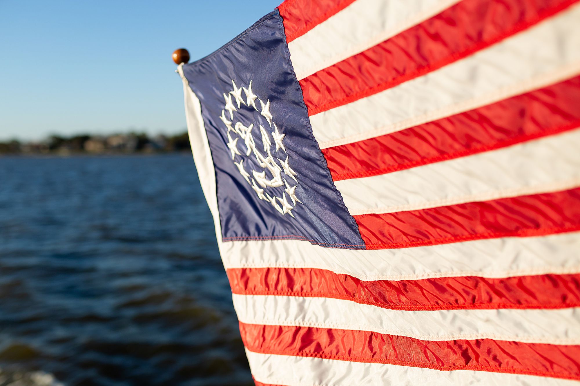 A red white and blue flag blows on the stern of a yacht in Kemah, Texas.