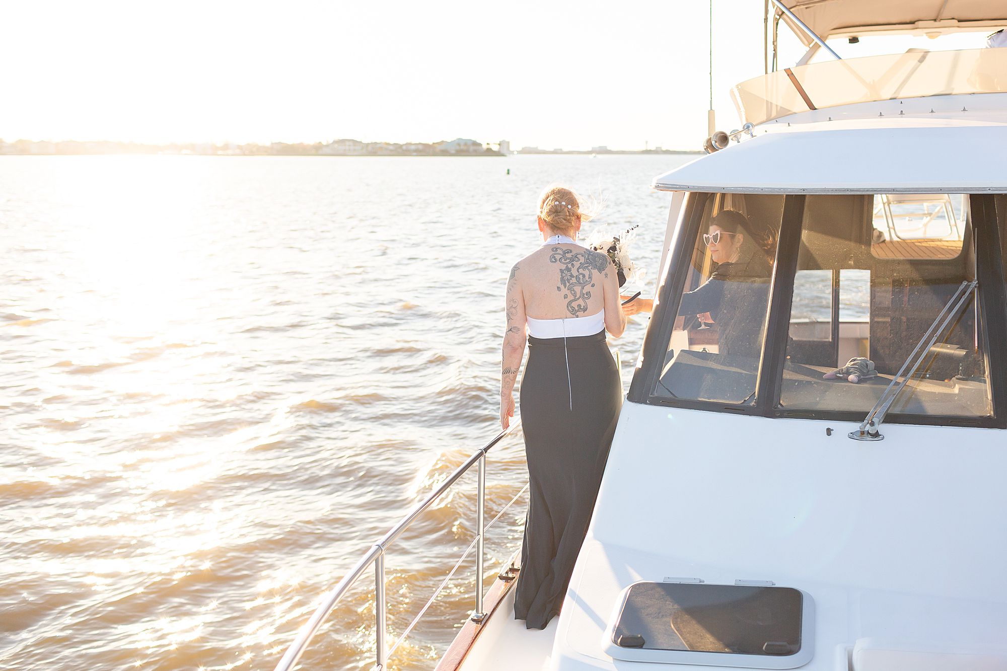 A bride walks to the stern of a yacht sailing on Clear Lake in Kemah, Texas at sunset.